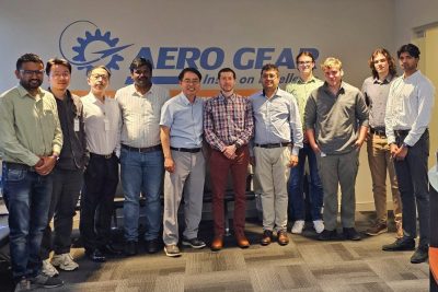 aero gear group standing in front of company logo